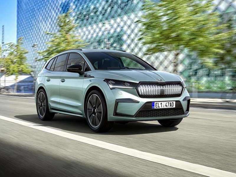 blue skoda enyaq iv driving on road