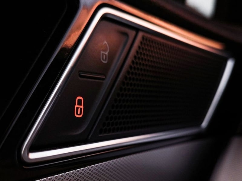 Detailed view of a modern car interior lock panel with light indicator.