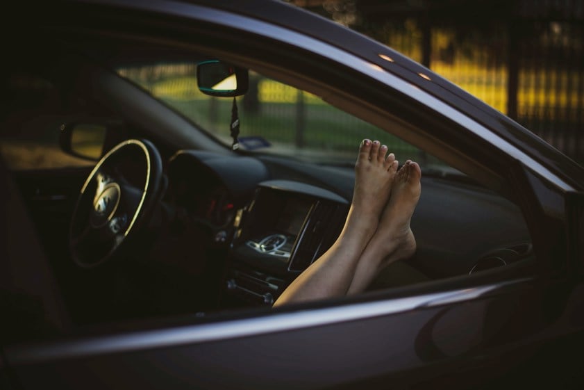 woman with bare feet on dashboard