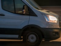 a white van driving down a street at night