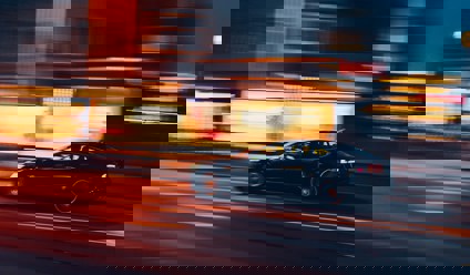 Saloon car driving at night with time span effect
