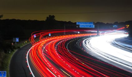 Long exposure shot of a highway at night with striking light trails.