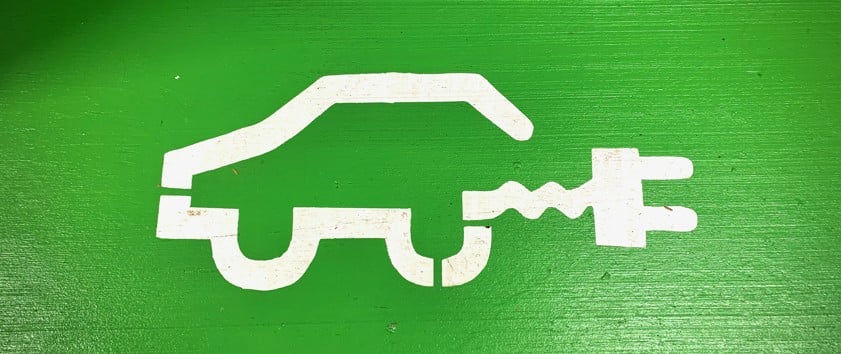 white ev car on green background
