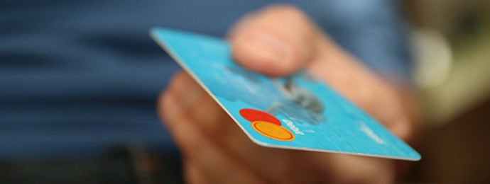 blue credit card being handed over