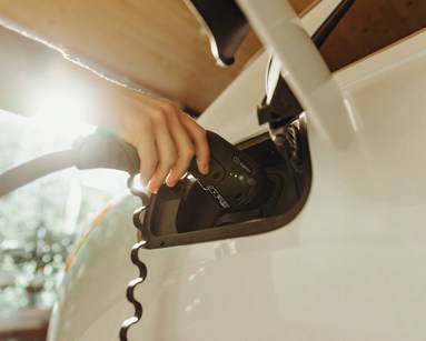 Person charging an electric car at home