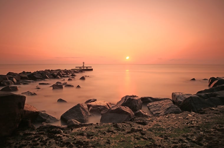 The sun rising over the Ness Point monument in Lowestoft, Suffolk in England