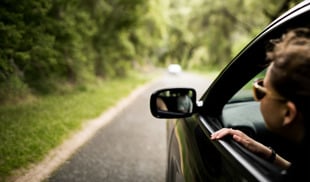 woman with head outside car window