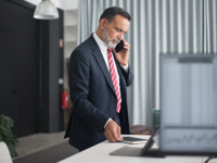 Professional man in a business suit on a phone call in a modern office setting