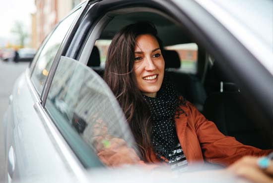 young woman driving business used lease car