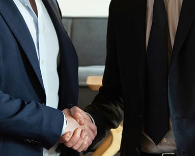 two business partners shaking hands in agreement
