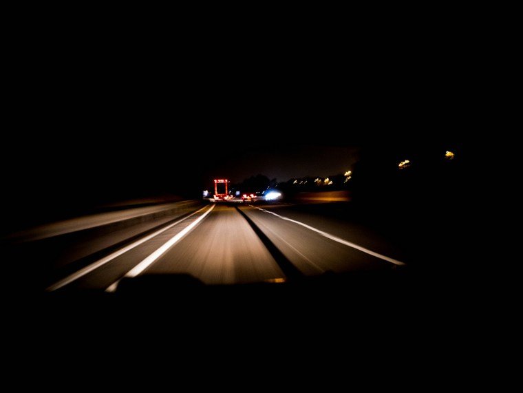 Motorway at night lit up by headlights