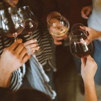close up of group of friends clinking glasses