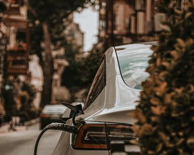 White electric car charging on an urban street