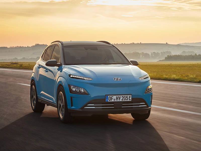 Hyundai Kona on a road with misty forest on the background