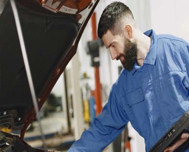 mechanic looking under bonnet of car