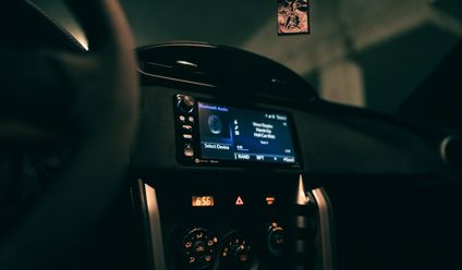 car dashboard showing an audio system display in a dimly lit interior