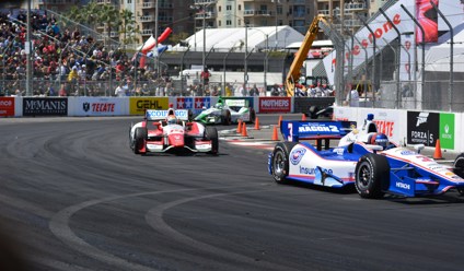 a group of racing cars driving down a race track