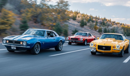 Old-school muscle cars driving on an open highway in Ankara, Türkiye, during fall.