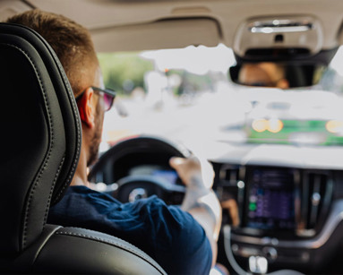 Man driving a car with two hands on the steering wheel