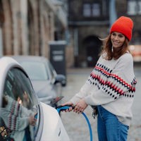 young woman charging an electric car