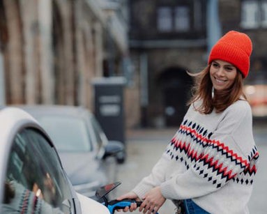 young woman charging an electric car