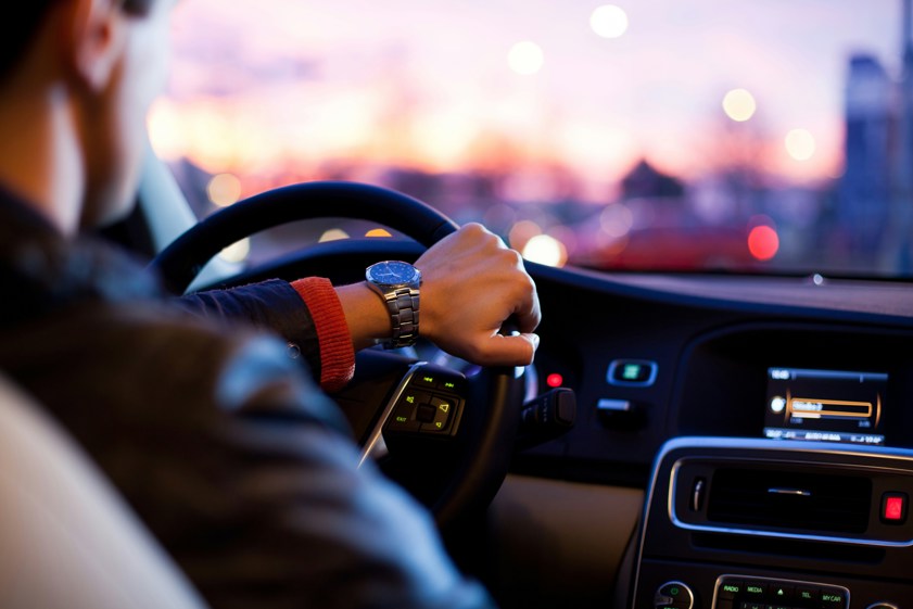 man driving a car whilst wearing a wrist watch