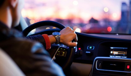 man driving a car whilst wearing a wrist watch