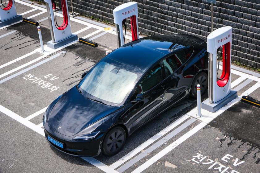 Black Tesla charging using Tesla chargers