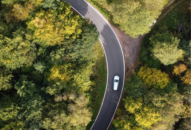 an aerial view of a winding road surrounded by trees