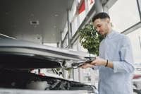 Man opening a car bonnet in a showroom