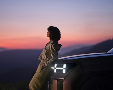 A woman sitting on the hood of a car