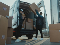 man and woman unloading boxes from a van