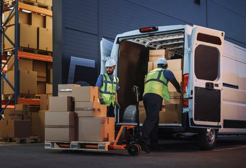 Happy Workers Loading Delivery Truck with Cardboard Boxes