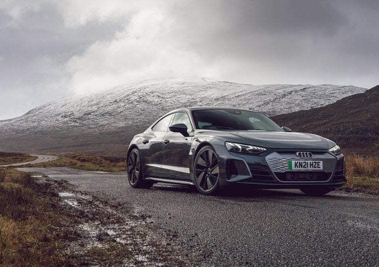 Audi e-tron GT parked on a road with snowy mountain in background