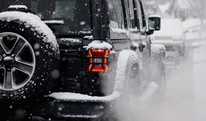 a jeep driving down a snow covered road