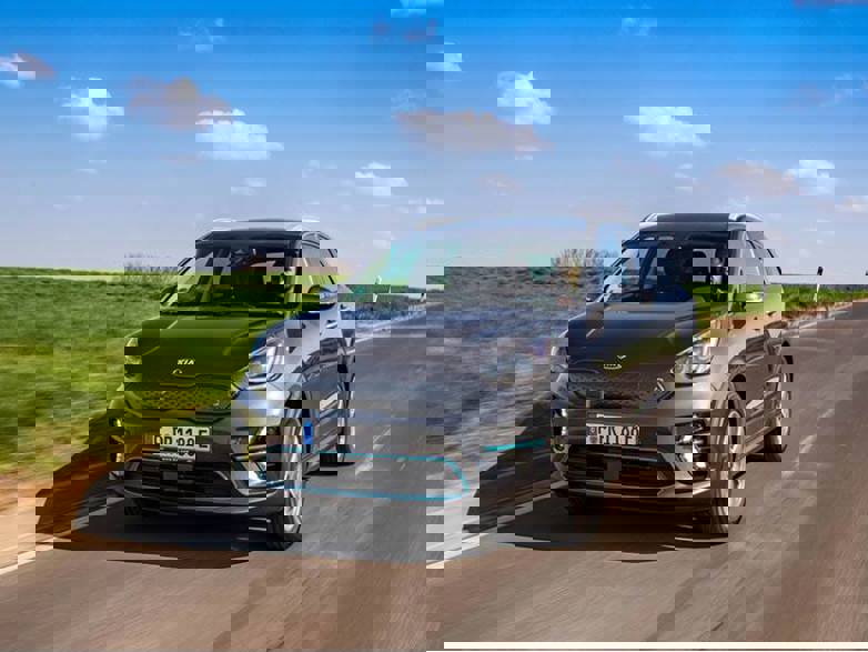 grey kia e-niro driving on road