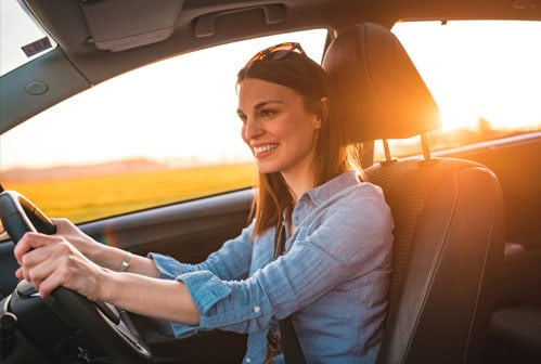 Young woman driving car on a sunny day