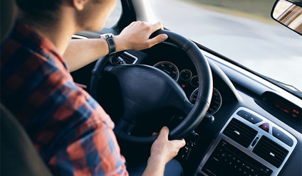A person driving a car with a calm expression on their face.