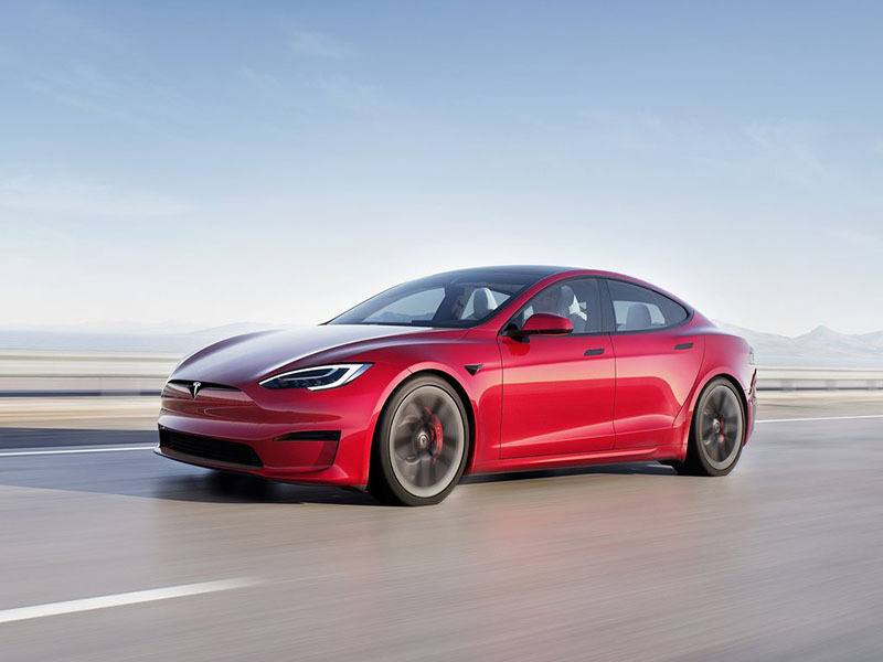 red tesla model s driving on the road