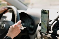 Person driving car with phone on the dashboard