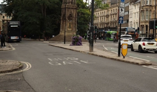 Street scene in Oxford featuring historic architecture and a central monument.