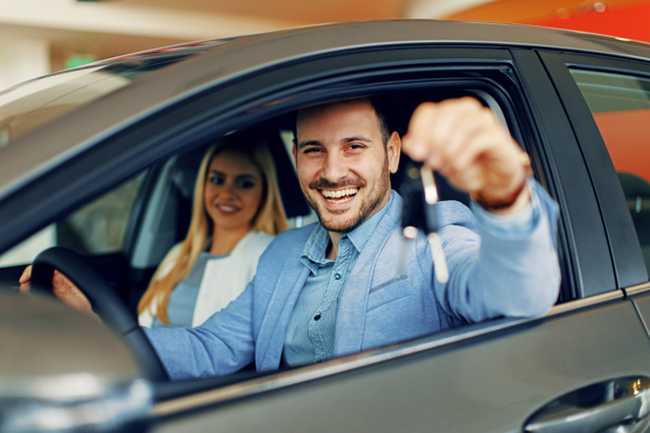 Young couple holding the keys of a new car