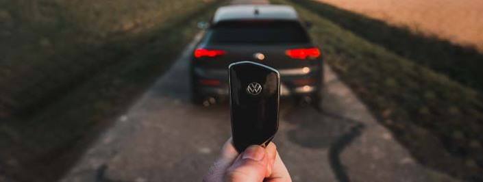 volkswagen car keys with a car in the background
