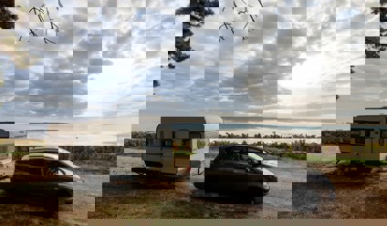 Car with a caravan attached with mountains in background
