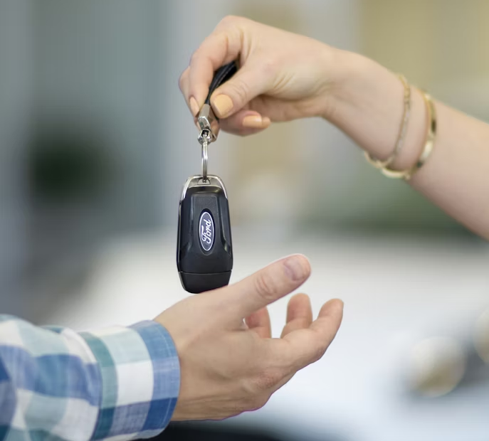 a person handing a car key to another person