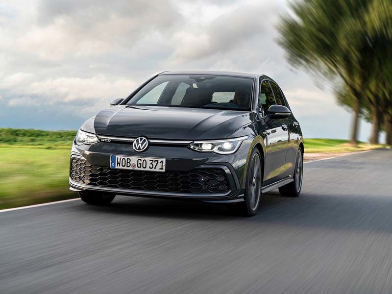 Black Volkswagen Golf Hatchback on a tree-lined road