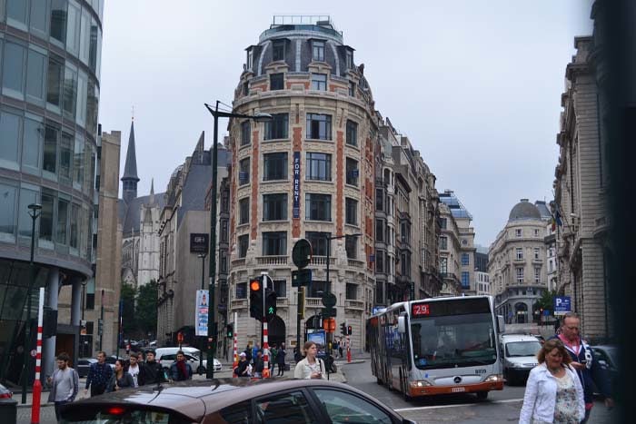 a city street filled with lots of traffic next to tall buildings