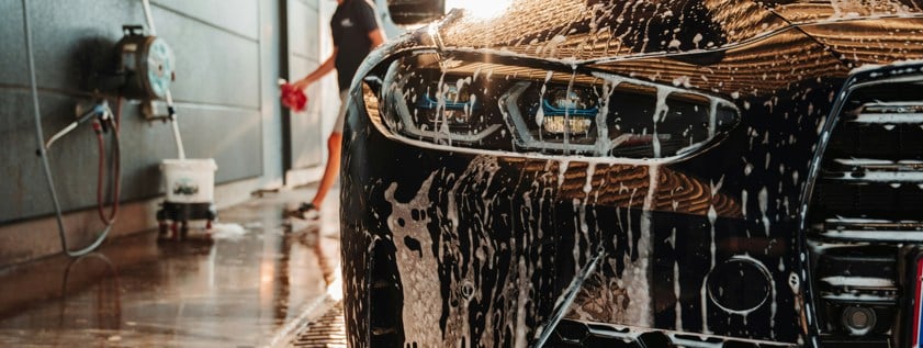 a man washing a sports car in garage