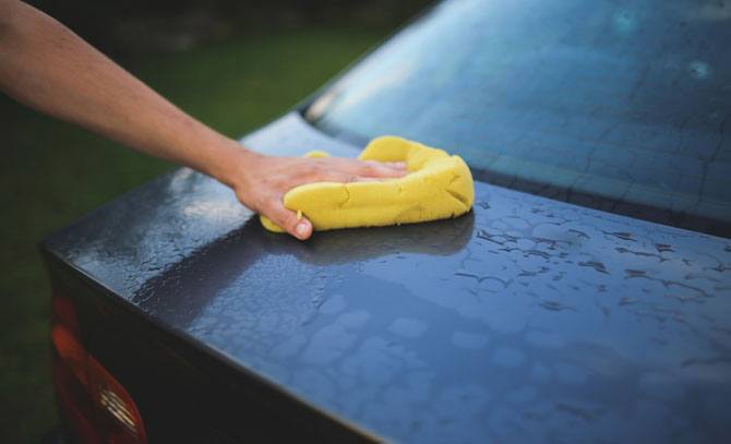 Person washing a car during a spring clean.