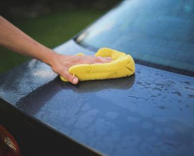 Person washing a car during a spring clean.